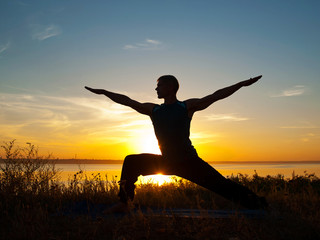 Man in yoga warrior pose standing  outdoors