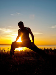 Yoga Athlete performing asana at sunset
