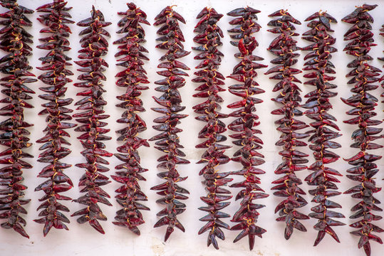 Espelette pepper strings hanging against a white wall
