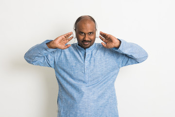 indian male enjoying music in traditional wear