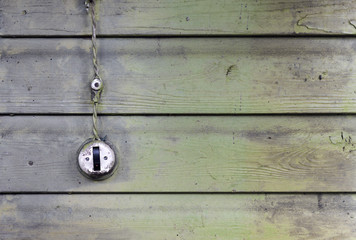 Vintage weathered light switch and wire on old wooden wall background