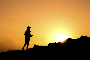 Silhouette of women walking on the mountain at sunset
