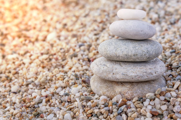 Fototapeta na wymiar Stack of zen stones on beach with burning sun