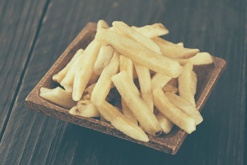 french fries on wood background - soft focus with vintage film f