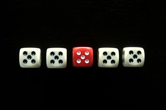 One Red game dice and four white game dice