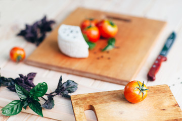 Cooking background. Tomatoes, basil, cheese on wooden table