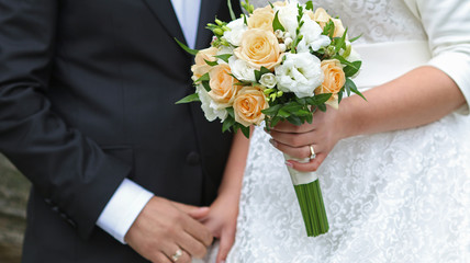 Obraz na płótnie Canvas bride hands holding wedding bouquet