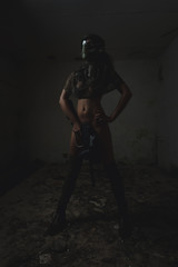 Fototapeta na wymiar Naked woman with paintball gun posing deserted, ruinous building