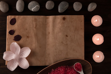 Beautiful Spa composition with aroma candles and empty vintage open book on wooden background. Treatment, aromatherapy