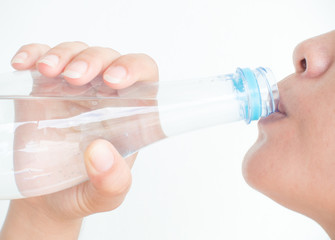 Close up woman drinking water from bottle on white background, Healthy concept.