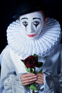 Sad mime Pierrot with a red rose