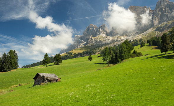 Hut In Alpine Meadow And Dolomites In The Background
