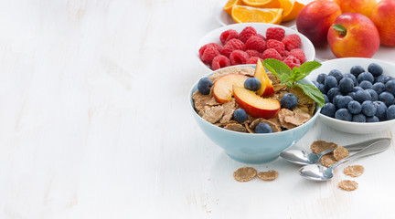 whole-grain flakes with fruit and berries on white wooden table
