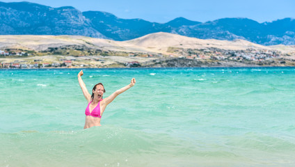 Woman is jumping out of water celebrating healthy lifestyle