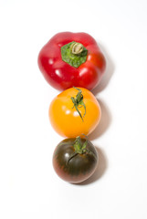 Two tomatoes and peppers on over white