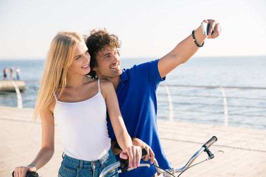 Man and woman making selfie photo on smartphone