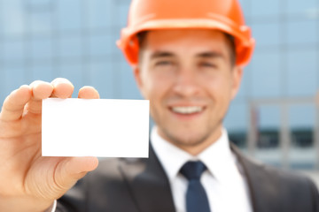 Handsome architect showing business card