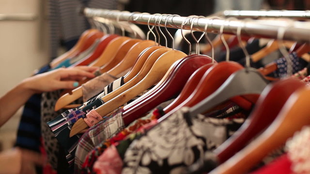 happy girl choosing new garment in fashion store