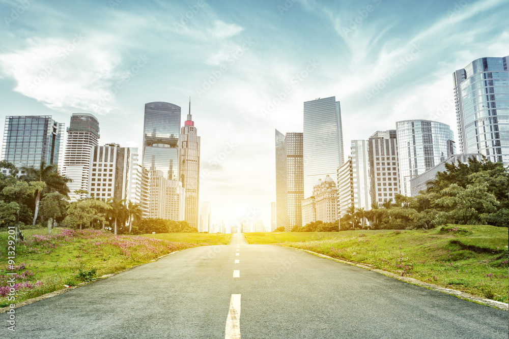 Wall mural asphalt road and skyscrapers under sunbeam