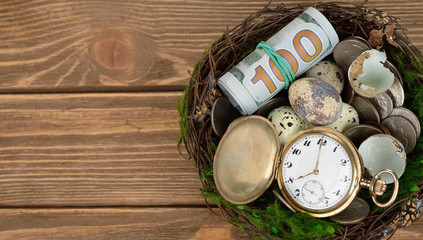 Obraz na płótnie Canvas Watches, money, and eggs in a nest