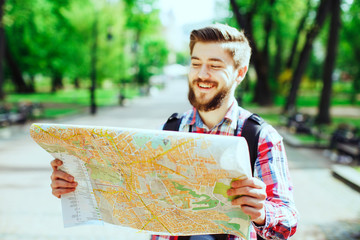 young tourist laughing and looking at the map
