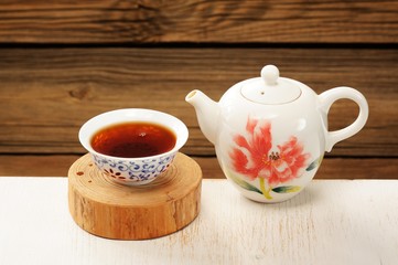 Puerh tea in white bowl brewed in white porcelain pot