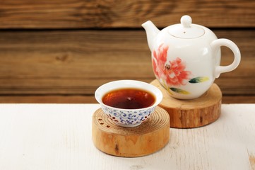 Ripe puerh tea in white bowl brewed in white porcelain pot