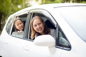 Happy Asian family sitting in the car