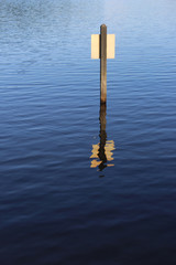 reflection of a wooden post in water