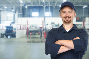 Smiling car mechanic in auto repair service.
