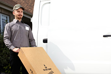 Postman with parcel near delivery truck.