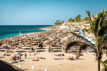 Tuinposter People sunbathing in the picturesque El Duque beach © Alex Tihonov