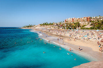 People sunbathing in the picturesque El Duque beach © Alex Tihonov