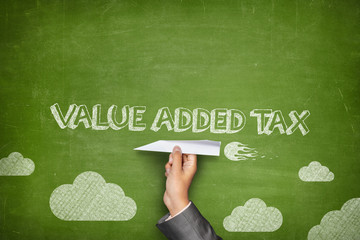 Value added tax concept on blackboard with paper plane