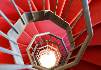 Fototapeta premium modern spiral staircase with red carpet