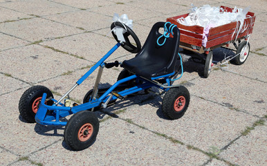 pedal go-kart with a cart with flakes stuck to the bride and gro