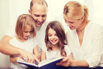smiling family and two little girls with book