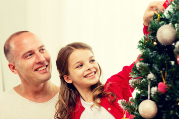 smiling family decorating christmas tree at home