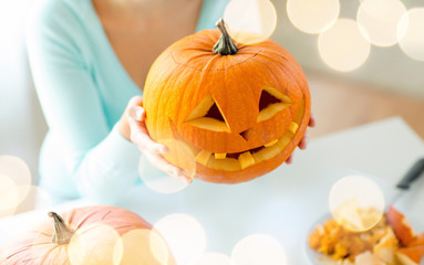 close up of woman with pumpkins at home