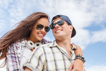 smiling teenagers in sunglasses having fun outside