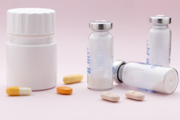 The set of medicine bottles, colorful pills and injection