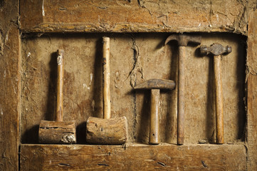 old wooden and metallic  hammers tools on antique wooden panel