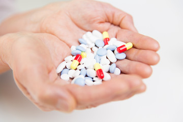 close up of senior woman hands with pills