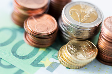 close up of euro paper money and coins on table