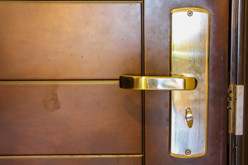 The metal door handle on a brown door for lock