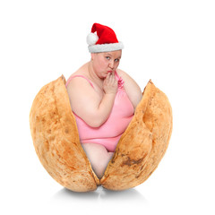  Funny gift with christmas surprise. Overweight woman with Santa cap in the nutshell isolated on white background.