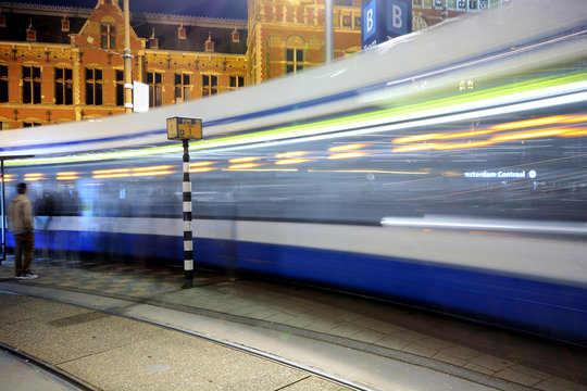 Straßenbahn oder Tram bei Nacht vor Hauptbahnhof von Amsterdam