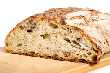 Pagnotta con noci casereccia tagliata e isolata su sfondo bianco