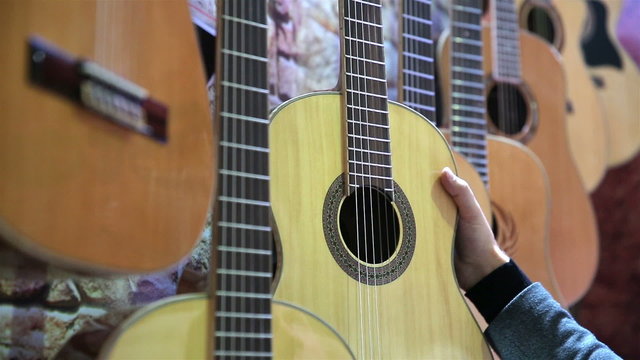Many beautiful acoustic guitars on the stand.