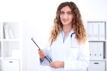 Friendly smiling young female doctor, isolated over white background